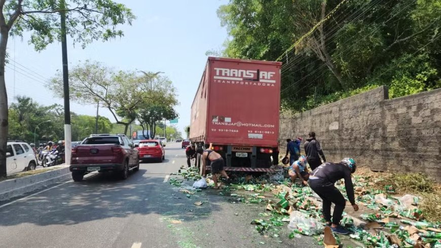 Caminhão carregado com cerveja tomba e moradores aproveitem para pegar latas e long neck