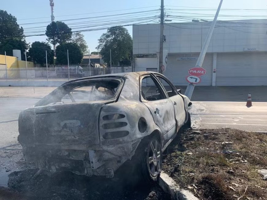 Carro colide com poste e pega fogo