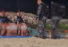 Homem faz sexo oral em mulher no meio de praia lotada.
