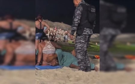 Homem faz sexo oral em mulher no meio de praia lotada.